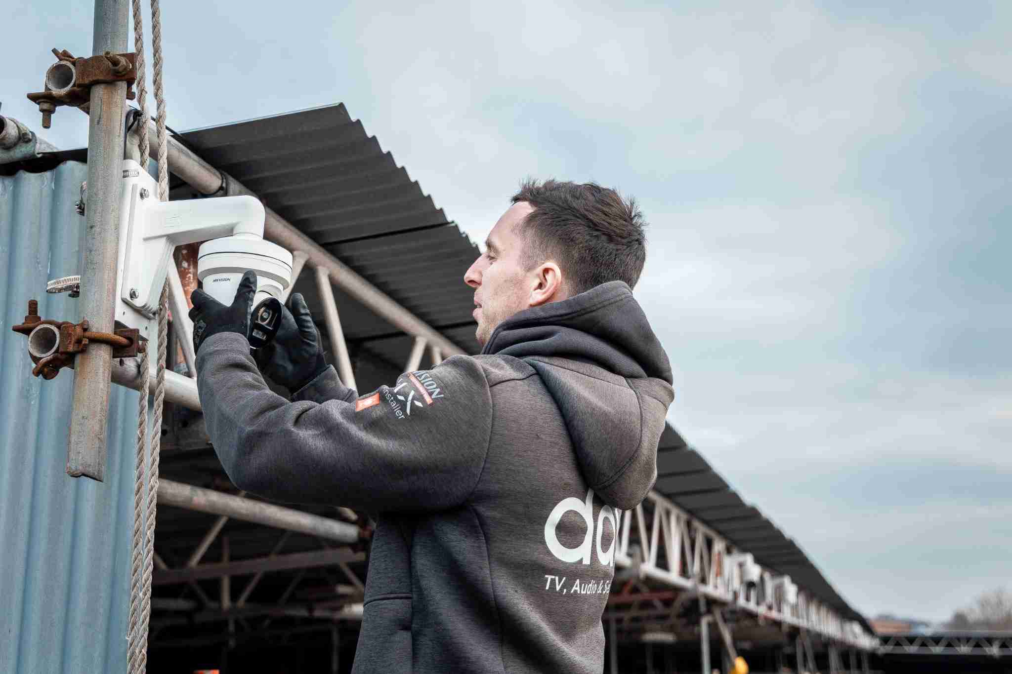 DAV engineer fitting an 8MP Hikvision CCTV camera at a commercial scaffolding yard